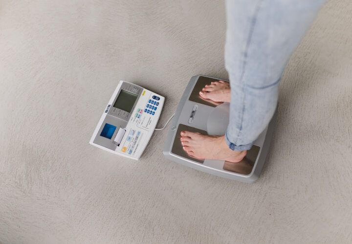 Voeten op een weegschaal met een meetapparaat ernaast